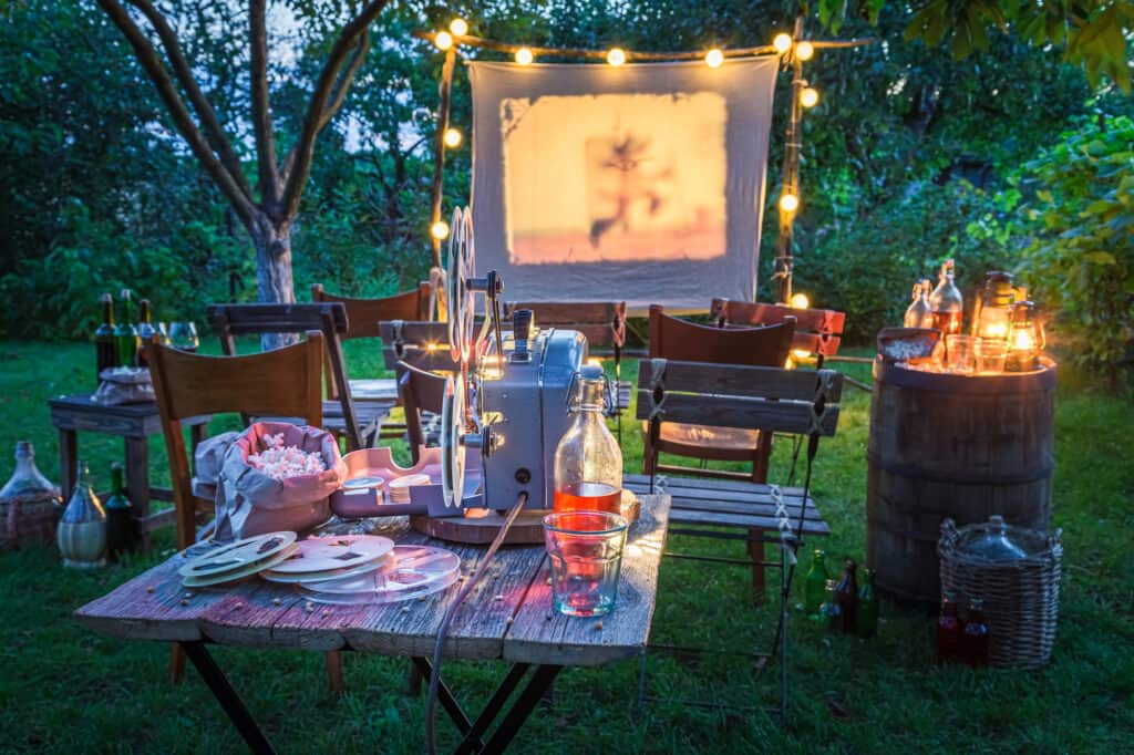 Open air summer cinema with drinks and snacks in evening Summer cinema in the home garden.